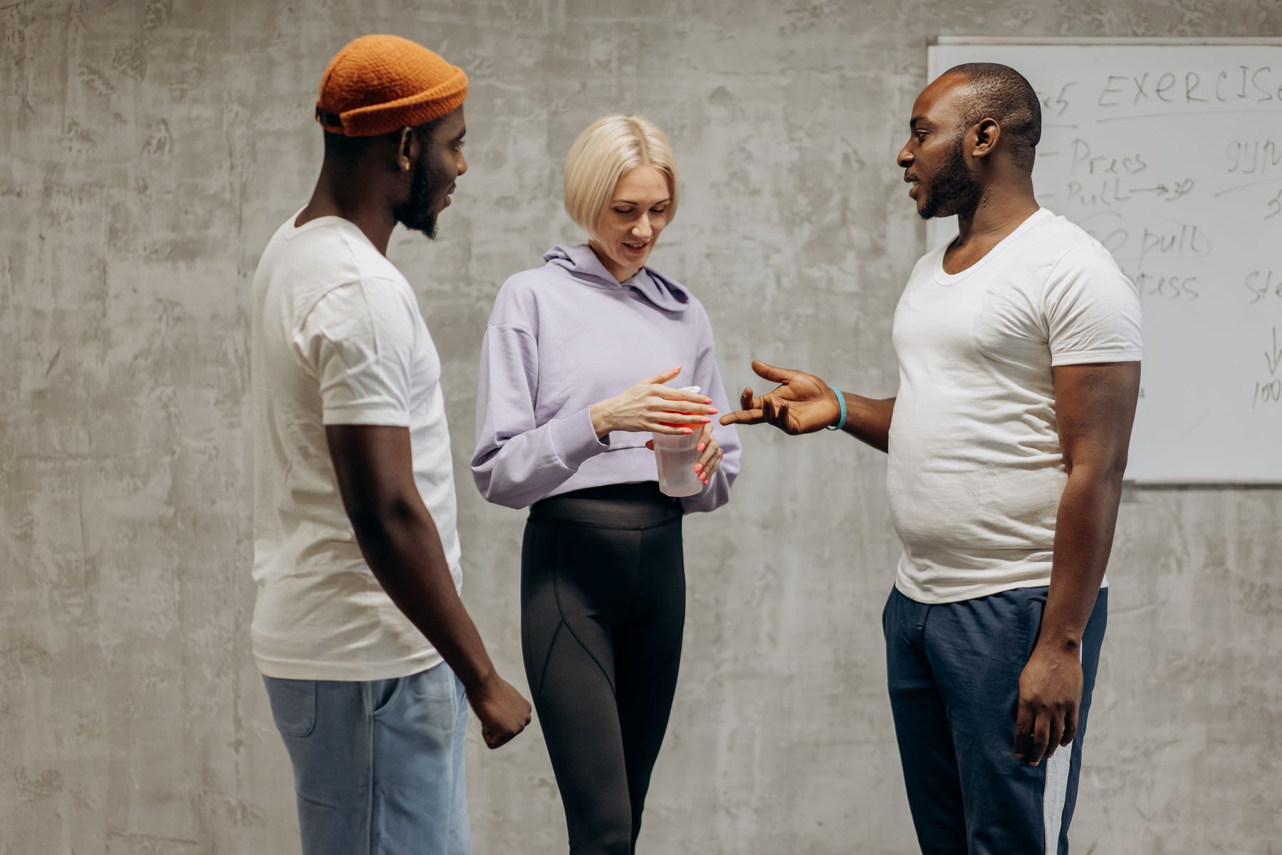 Three people discussing exercise and wellbeing after a training session
